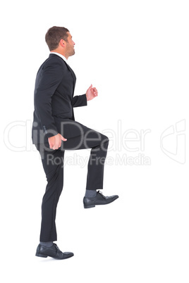 Businessman walking with his leg up