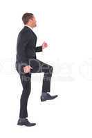 Businessman walking with his leg up