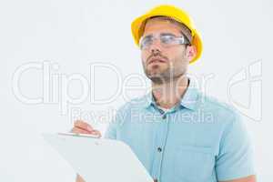 Supervisor looking away while writing on clipboard