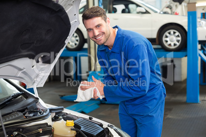 Mechanic examining under hood of car