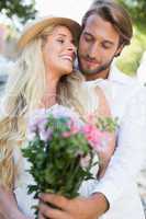 Attractive couple smiling at flowers