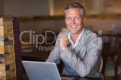Smiling businessman using his laptop Smiling businessman using his laptop