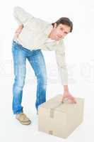 Delivery man with cardboard box suffering from back ache