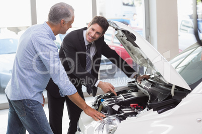 Two men looking at a car engine