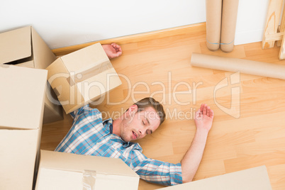 Man lying under fallen boxes