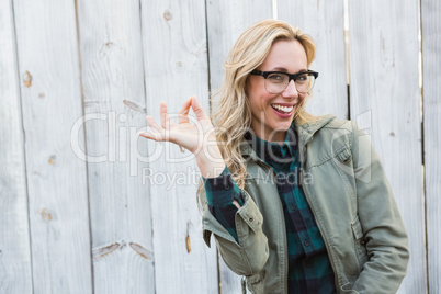 Happy blonde in glasses making okay gesture