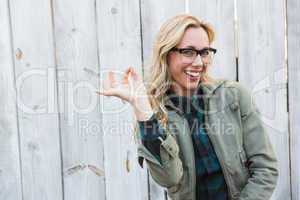 Happy blonde in glasses making okay gesture