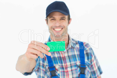 Happy plumber showing green card