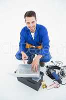 Smiling construciton worker pointing at laptop