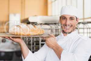 Baker holding a freshly baked loaf