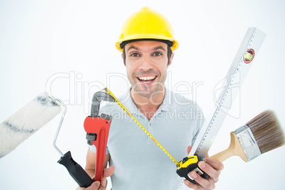 Portrait of happy worker holding various equipment
