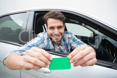 Young man smiling and holding card