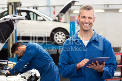 Smiling mechanic using a tablet pc