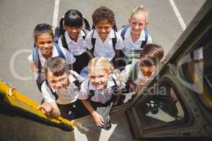 Cute schoolchildren getting on school bus