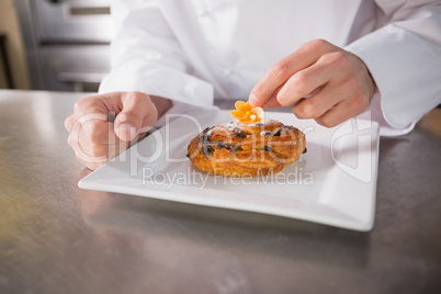 Close up of baker putting flower on the pastry