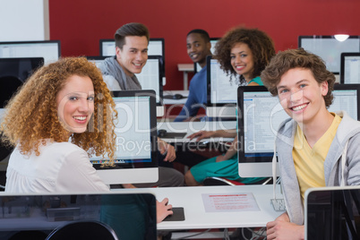 Students smiling at camera in computer class