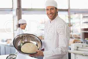 Baker showing dough in mixing bowl
