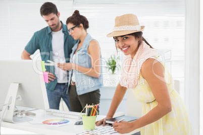 Smiling designer in front of colleagues using colour wheel