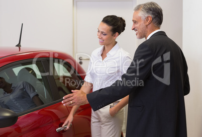 Businessman showing a car to a woman Businessman showing a car to a woman