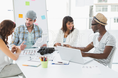 Smiling colleagues sitting at desk interacting