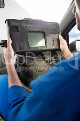 Mechanic using diagnostic tool in the car