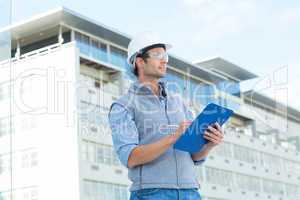 Architect looking away while writing on clipboard