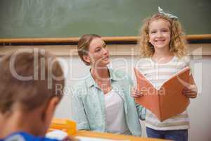 Cute pupil smiling at camera during class presentation