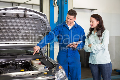 Mechanic showing customer the problem with car