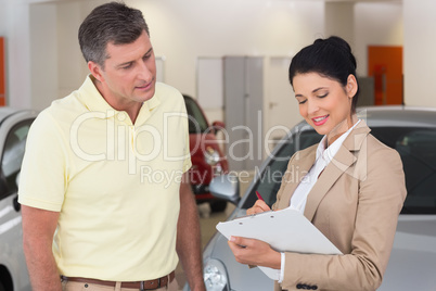 Smiling businessman undersign a car contract