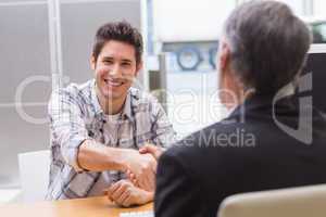 Smiling customer shaking a salesman hand