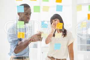 Concentrated coworkers looking at sticky notes