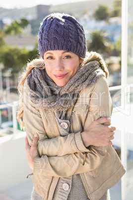 Cold blonde in warm clothes looking at camera