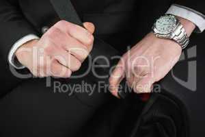 Close up of businessman putting on his seat belt
