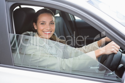 Pretty businesswoman smiling and driving