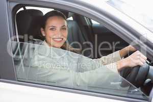 Pretty businesswoman smiling and driving