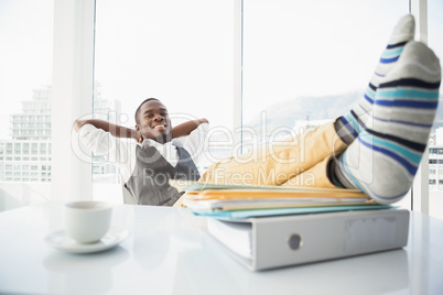 Relaxed businessman sitting in his chair with feet up