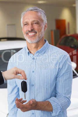 Businessman giving car key to happy customer