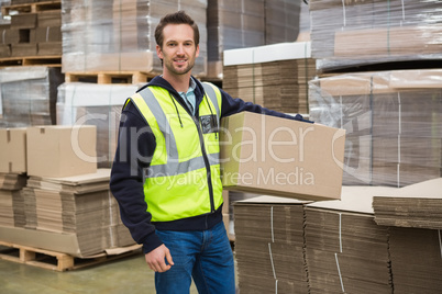 Worker carrying box in warehouse