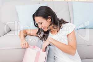 Pretty brunette opening shopping bag