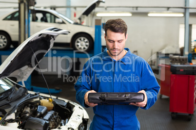 Mechanic examining under hood of car