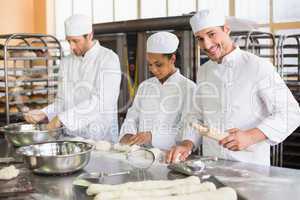 Team of bakers preparing dough