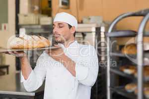 Baker smelling a freshly baked loaf