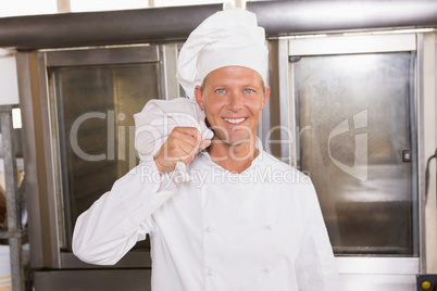 Smiling baker holding bag of flour