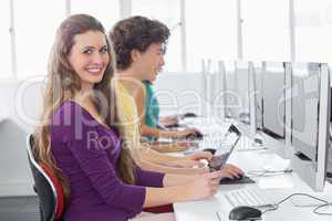 Student smiling at camera in computer class