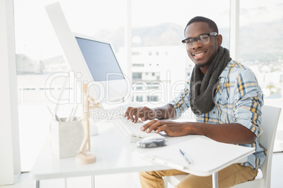 Smiling businessman typing on keyboard