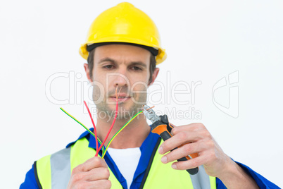 Handsome electrician cutting wire with pliers