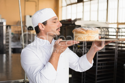 Baker smelling a freshly baked loaf