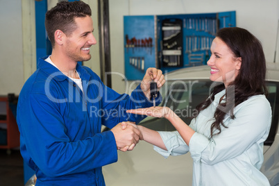 Mechanic giving keys to satisfied customer