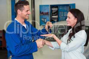 Mechanic giving keys to satisfied customer