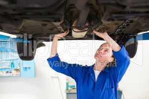 Mechanic examining under the car